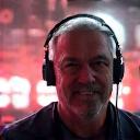 Portrait of a confident, experienced male technical director wearing a headset in a backstage event setting.